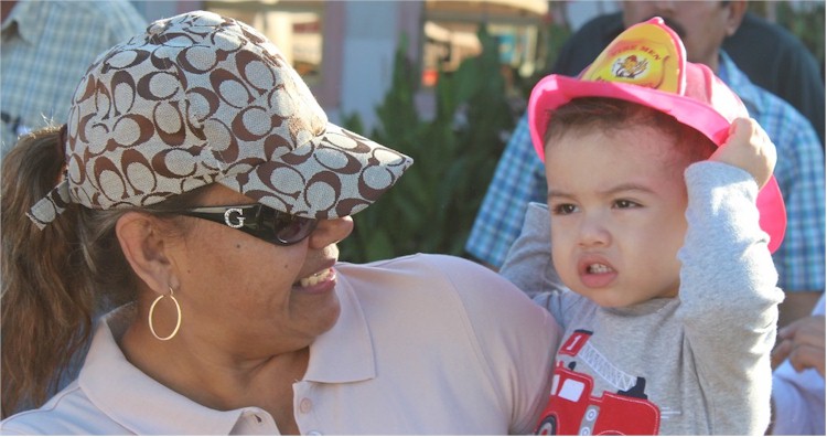 Desfile 20 de Noviembre: un niño vestido de bomberito junto a su mamá